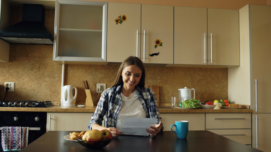Femme prenant son petit-déjeuner dans sa cuisine, illustration des habitudes alimentaires du matin après 50 ans